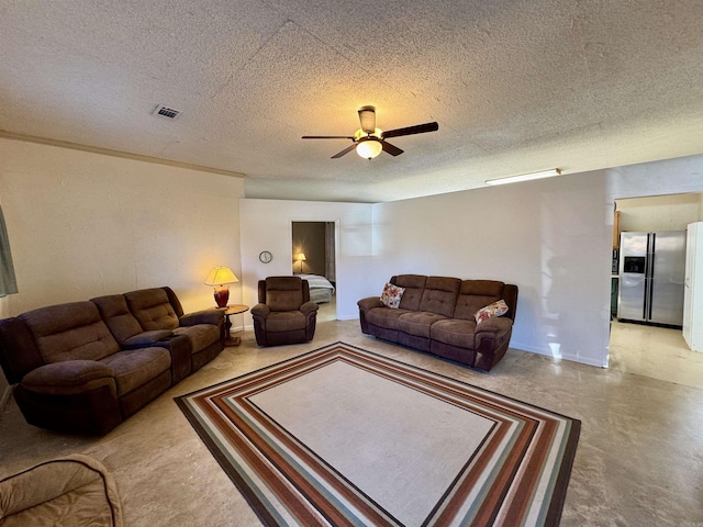 living room with ceiling fan, concrete flooring, and a textured ceiling