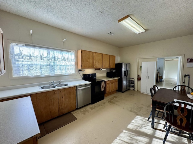 kitchen featuring a textured ceiling, stainless steel appliances, and sink