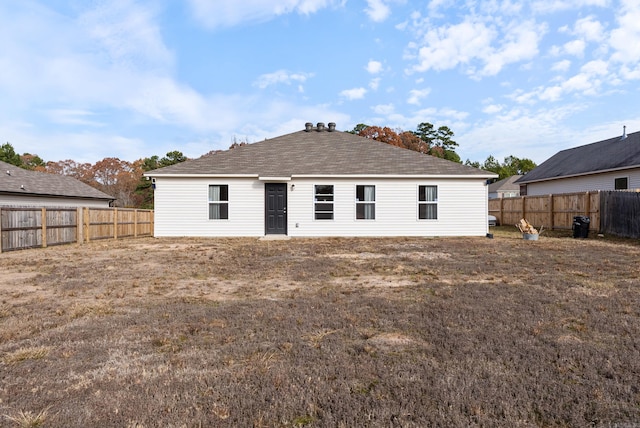 rear view of house featuring a lawn