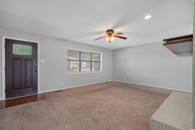 unfurnished living room featuring ceiling fan and carpet