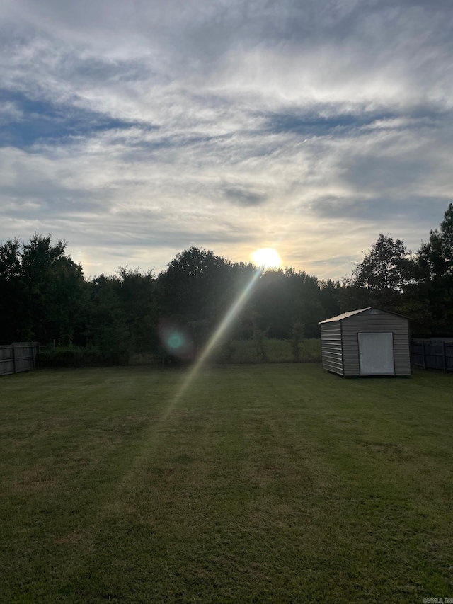 yard at dusk featuring an outbuilding