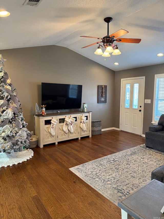 living room featuring vaulted ceiling, ceiling fan, and dark wood-type flooring