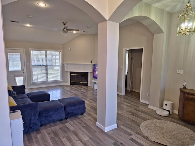 living room featuring hardwood / wood-style floors, ceiling fan with notable chandelier, and lofted ceiling