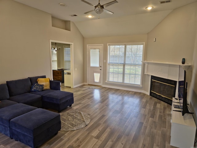 living room with hardwood / wood-style floors, high vaulted ceiling, and ceiling fan with notable chandelier