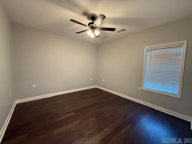 spare room with ceiling fan and dark wood-type flooring