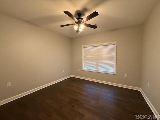 unfurnished room with ceiling fan and dark hardwood / wood-style flooring