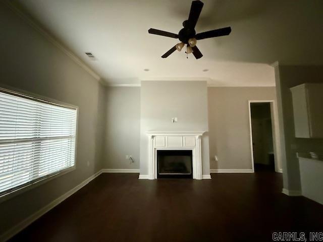 unfurnished living room featuring dark hardwood / wood-style floors, ceiling fan, and crown molding