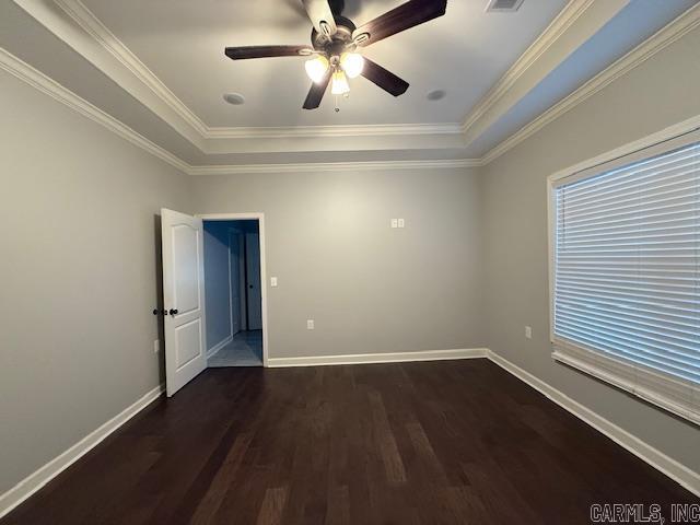 unfurnished room with dark hardwood / wood-style flooring, ornamental molding, and a tray ceiling