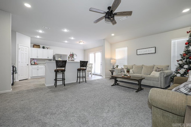 living room featuring light carpet and ceiling fan