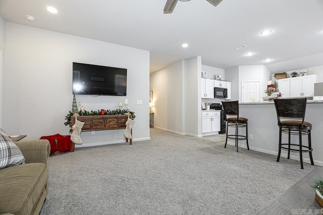 carpeted living room with ceiling fan