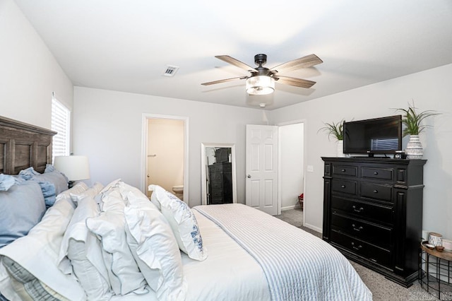 bedroom with ceiling fan, light carpet, and ensuite bath