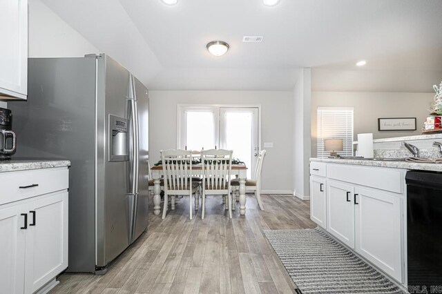 kitchen with stainless steel fridge with ice dispenser, black dishwasher, light hardwood / wood-style floors, and white cabinetry