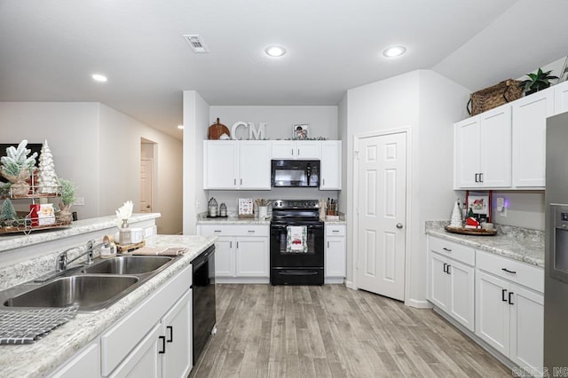 kitchen with white cabinets, sink, light hardwood / wood-style floors, and black appliances