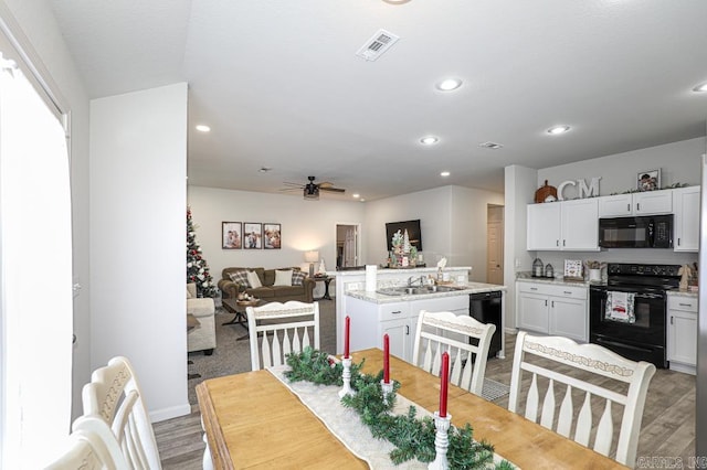 dining space featuring hardwood / wood-style flooring, ceiling fan, and sink