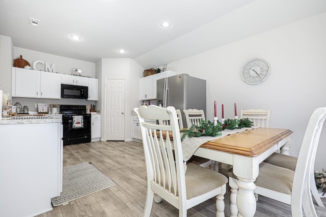 dining space featuring light wood-type flooring and sink