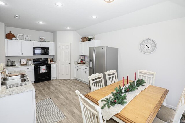 kitchen with sink, white cabinets, black appliances, and light hardwood / wood-style floors