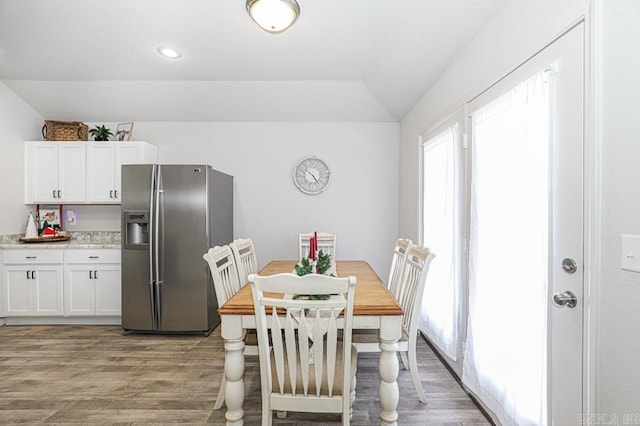 dining area with lofted ceiling and light hardwood / wood-style flooring