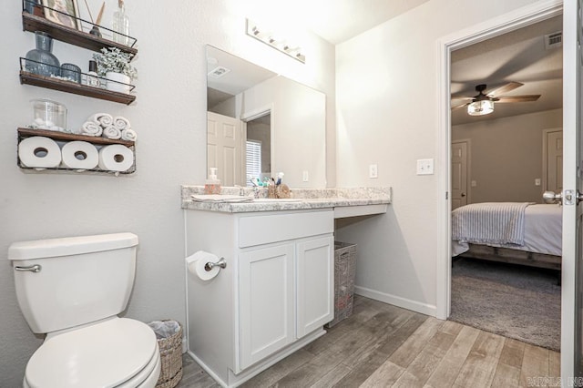 bathroom featuring ceiling fan, vanity, wood-type flooring, and toilet