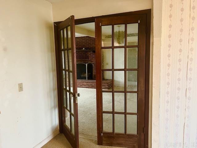 doorway with a fireplace, french doors, and carpet flooring