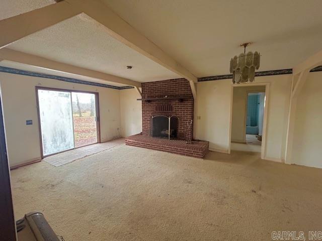 unfurnished living room featuring carpet, beamed ceiling, and a brick fireplace