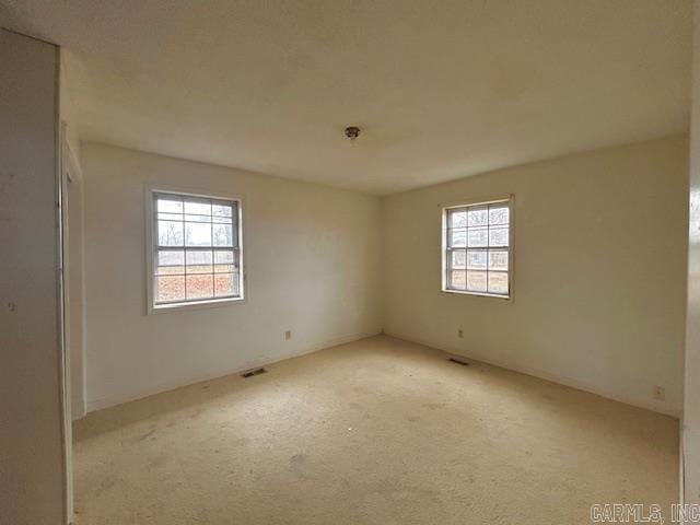 empty room with plenty of natural light and light colored carpet