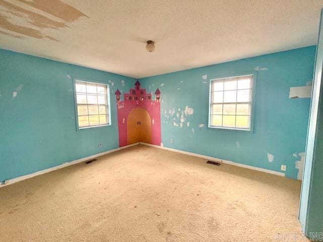 unfurnished room with carpet floors and a textured ceiling