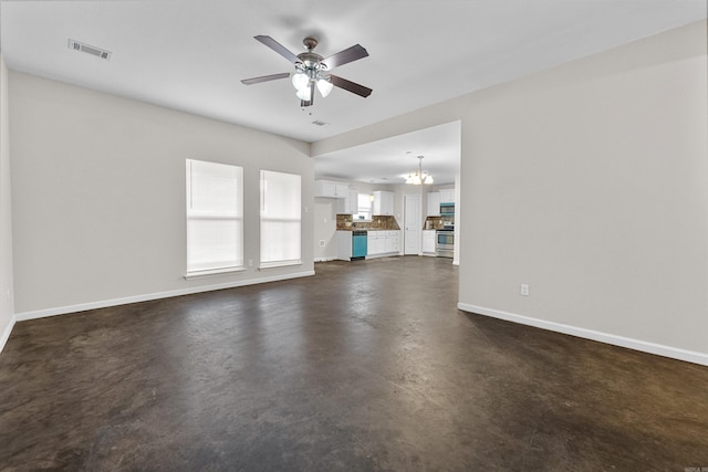 unfurnished living room featuring ceiling fan with notable chandelier