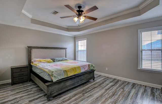 bedroom with multiple windows, hardwood / wood-style flooring, ceiling fan, and ornamental molding