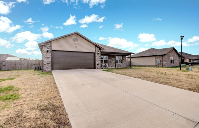 view of front of property featuring central air condition unit, a front lawn, and a garage