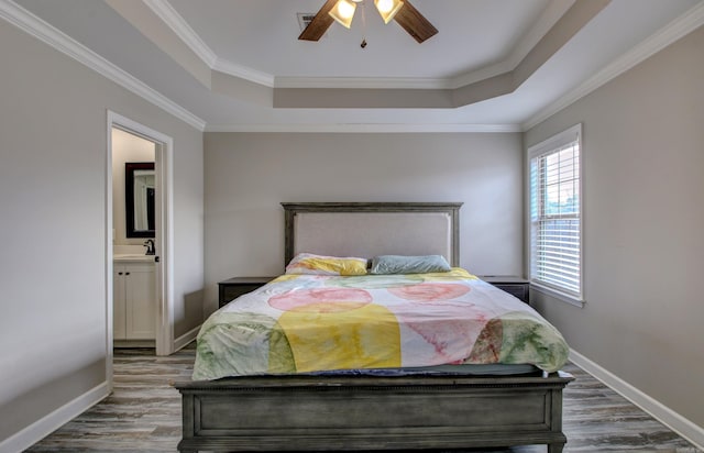 bedroom featuring wood-type flooring, ensuite bath, ceiling fan, and crown molding