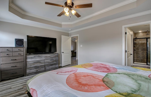 bedroom with a raised ceiling, ensuite bath, ceiling fan, and ornamental molding