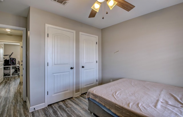 bedroom with ceiling fan and dark hardwood / wood-style flooring