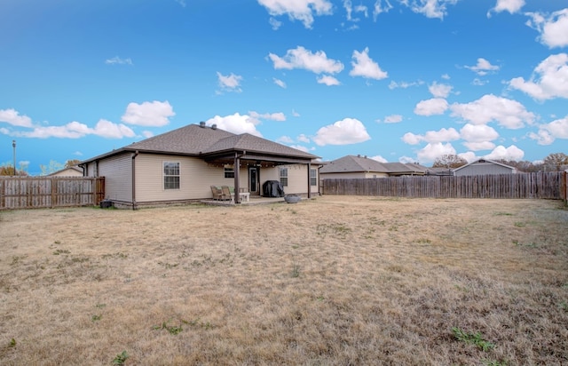 back of property with a lawn and a patio area