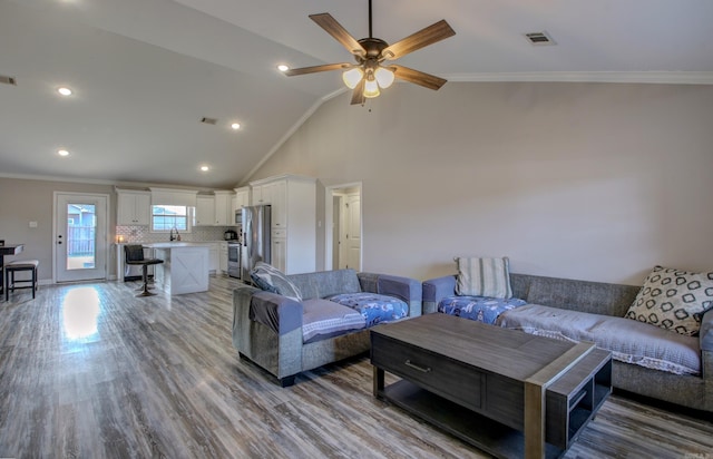 living room featuring sink, crown molding, vaulted ceiling, light hardwood / wood-style flooring, and ceiling fan