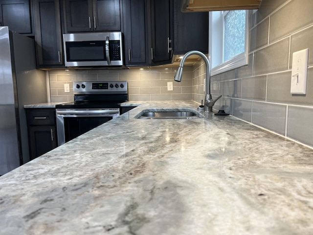 kitchen with decorative backsplash, appliances with stainless steel finishes, and sink