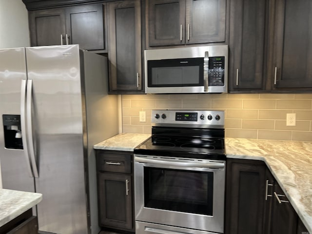 kitchen with dark brown cabinetry, decorative backsplash, light stone countertops, and appliances with stainless steel finishes