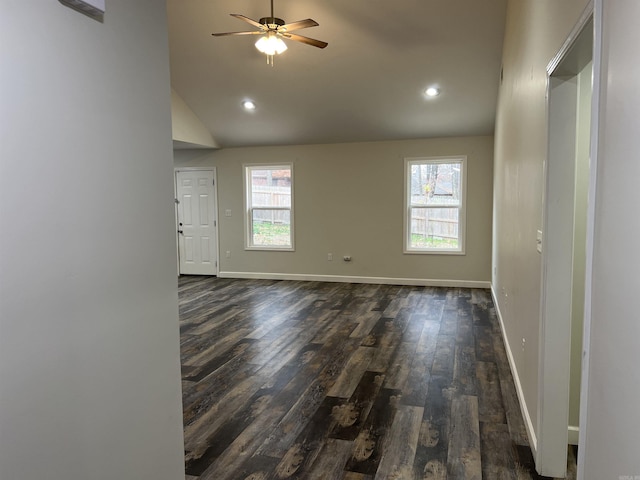 empty room featuring dark hardwood / wood-style floors, ceiling fan, and vaulted ceiling