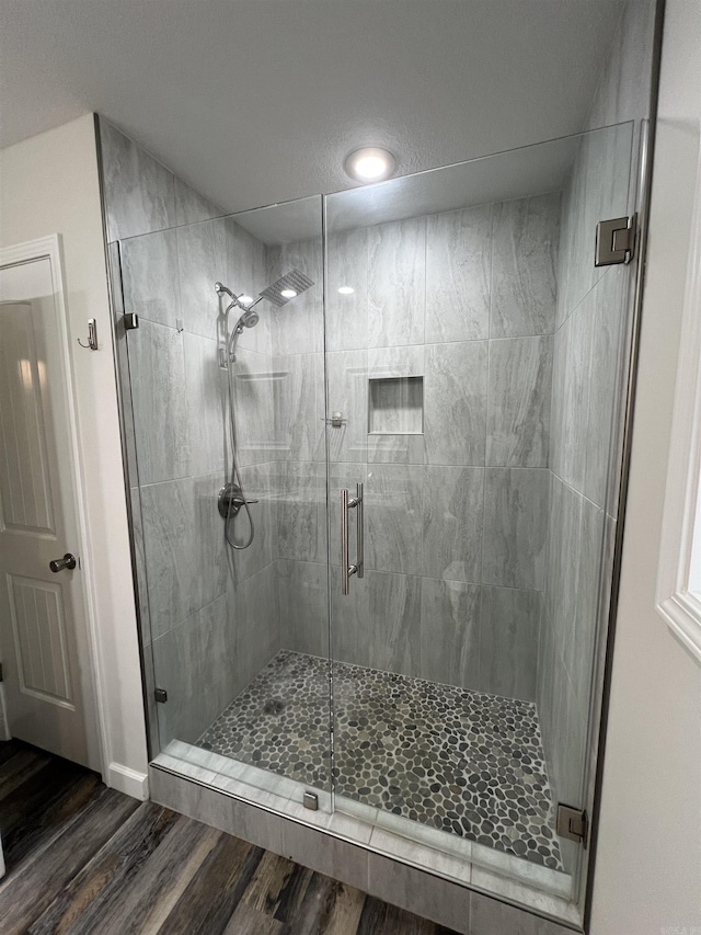 bathroom featuring a shower with door and hardwood / wood-style flooring