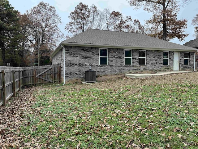 back of house featuring central air condition unit, a lawn, and a patio