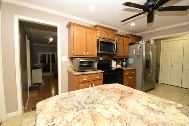 kitchen with backsplash, crown molding, light tile patterned flooring, and appliances with stainless steel finishes