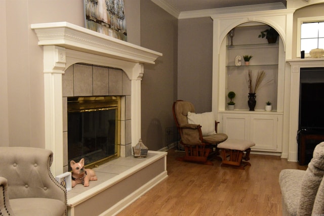 living room with a fireplace, light hardwood / wood-style floors, and ornamental molding