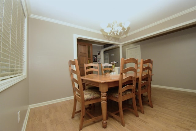 dining room with light wood-type flooring, crown molding, and a notable chandelier