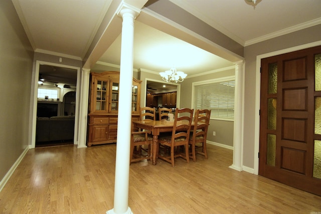 dining space with light wood-type flooring, an inviting chandelier, ornamental molding, and ornate columns