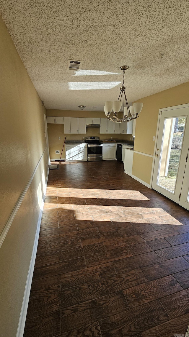 kitchen featuring pendant lighting, an inviting chandelier, electric range, dark hardwood / wood-style floors, and a textured ceiling