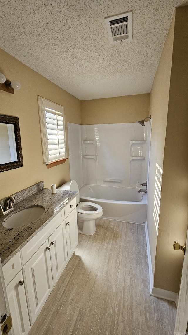 full bathroom with vanity, a textured ceiling, washtub / shower combination, hardwood / wood-style floors, and toilet