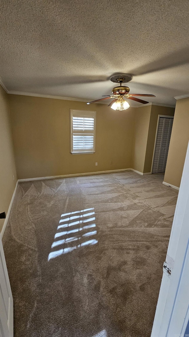 unfurnished room with crown molding, carpet, a textured ceiling, and ceiling fan