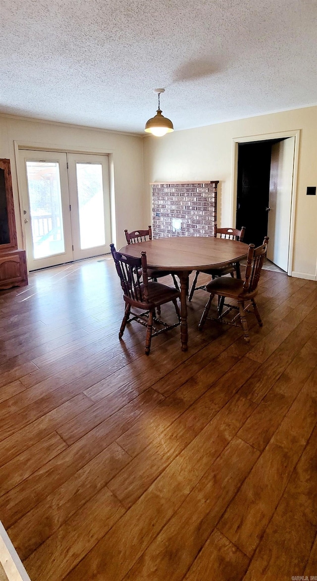 dining space featuring a textured ceiling and dark wood-type flooring