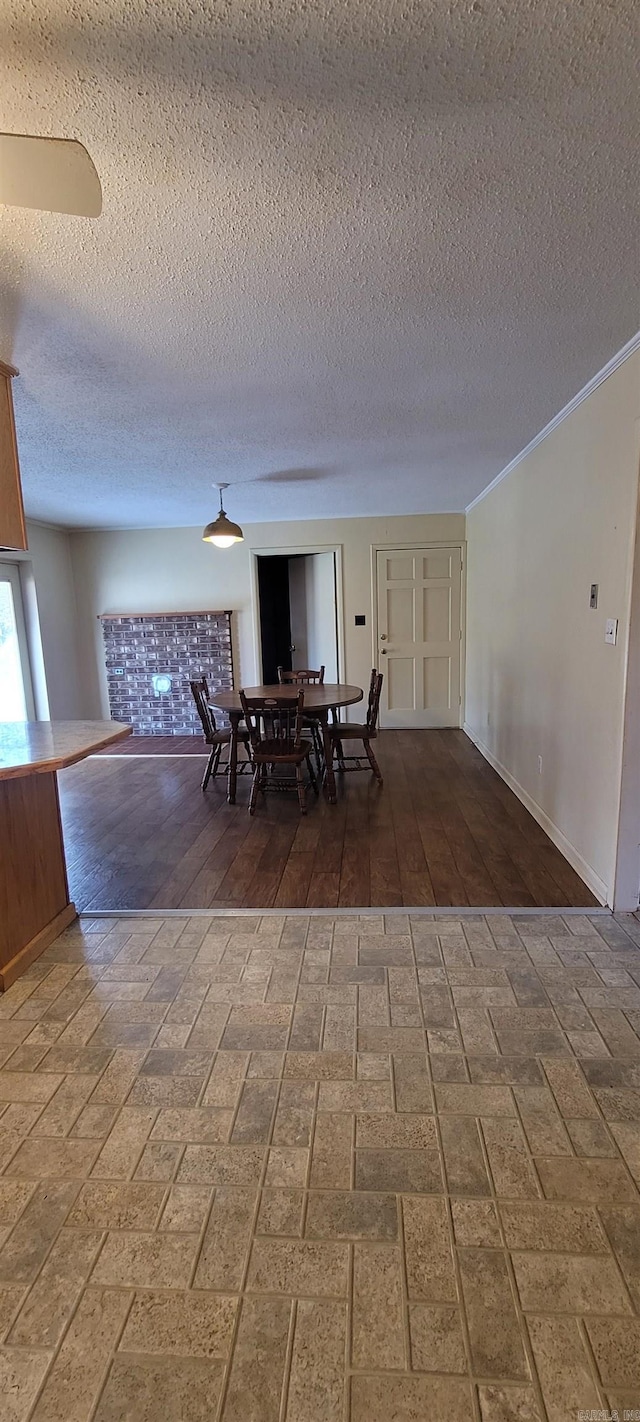 unfurnished dining area featuring hardwood / wood-style floors, a textured ceiling, and ornamental molding