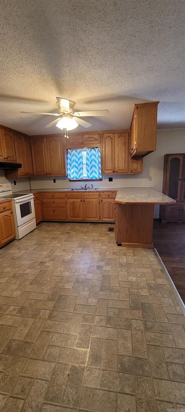 kitchen featuring kitchen peninsula, a textured ceiling, ceiling fan, sink, and white range with electric cooktop