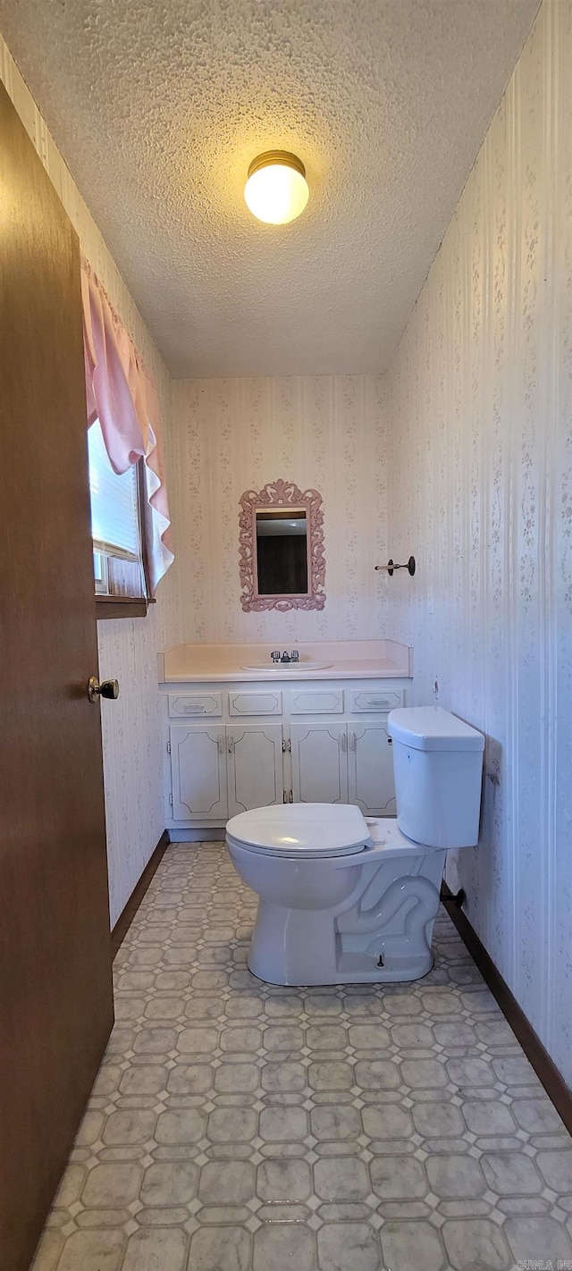 bathroom with vanity, a textured ceiling, and toilet